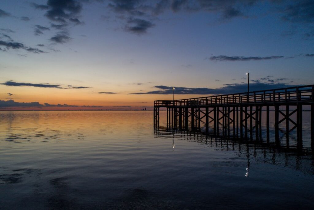 Scenic wooden boardwalk along Mobile Bay in Daphne, Alabama at sunset